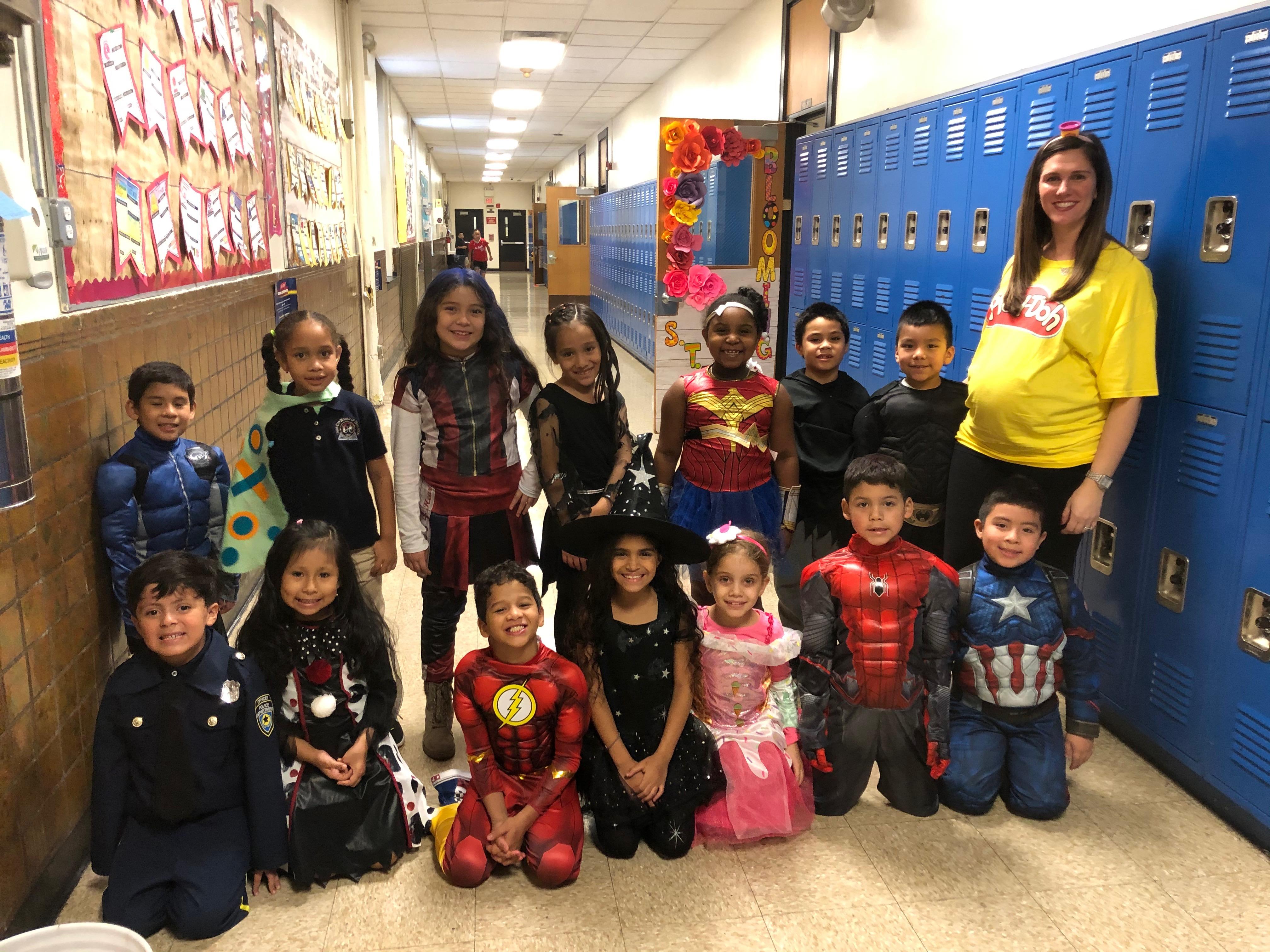 teacher with her class in the hallway showing off their costumes