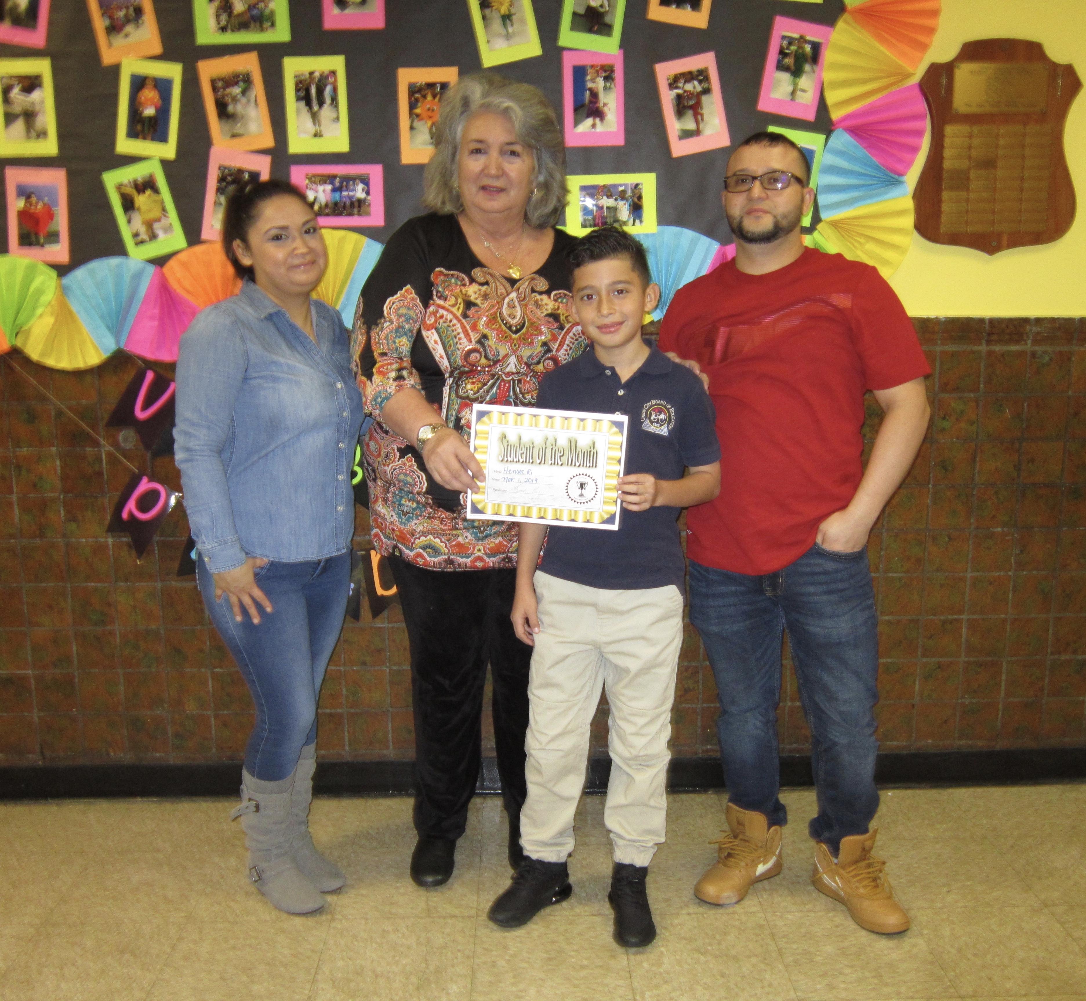 hanser R. his family and Principal Tierri receiving STudent of the month of nov. certificate